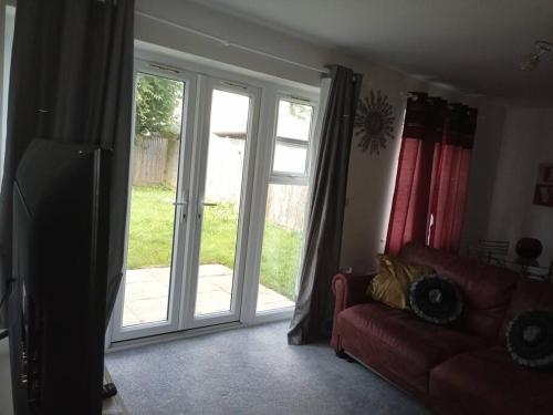 a living room with a sliding glass door at Stansted Airport Serviced Accommodation x DM for Weekly x Monthly Deals by D6ten Homes Ltd in Takeley