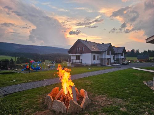 een vuurplaats in een tuin voor een huis bij Jagodowy Ski & Spa in Lasowka