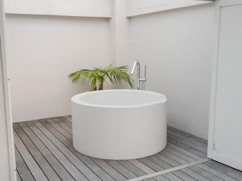 a white bath tub with a plant in a bathroom at Bstudio in Wakayama