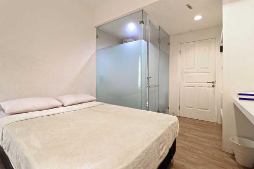 a bedroom with a bed and a glass shower at Rumah Kayu Manis Bintaro in Jakarta