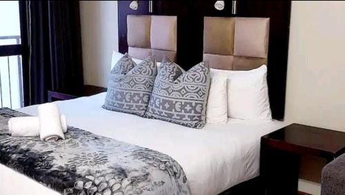 a bedroom with a large bed with pillows at Gautrain Hatfield Lovely Studio in Pretoria