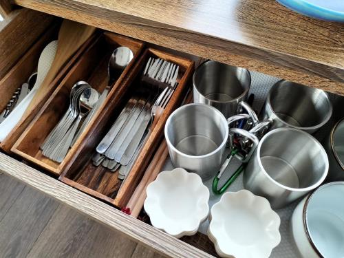 a drawer with dishes and utensils in a kitchen at 思い出になる九十九里の古民家ドマノマ ハンモック バーベキュー in Kujukuri