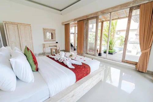 - une chambre avec un grand lit blanc et une couverture rouge dans l'établissement Masaia Villa 3Bed in Ubud, à Ubud