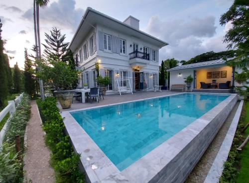 a swimming pool in front of a house at La Campagne Villa Chiangmai in Chiang Mai