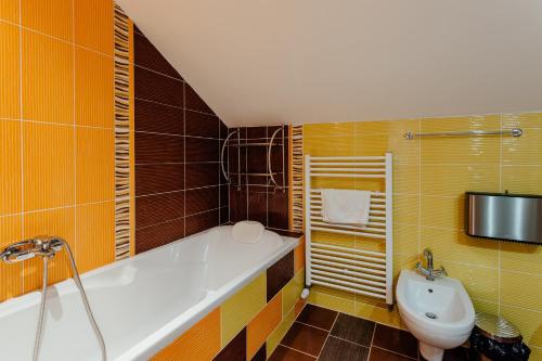 a bathroom with a tub and a toilet and a sink at Botanický dvor in Banská Štiavnica