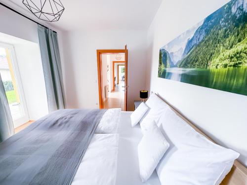 una camera da letto bianca con un grande dipinto sul muro di Idyllische Wohnung mit Garten! a Bad Gleichenberg