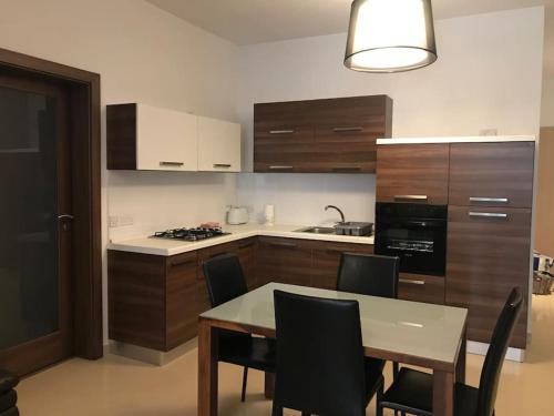 a kitchen with a table and chairs in a kitchen at Great location accommodation in St Paul's Bay