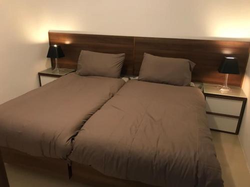 uma cama num quarto com dois candeeiros em ambos os lados em Great location accommodation em St. Paul's Bay