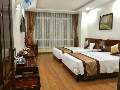Habitación de hotel con 2 camas y ventana en Khách Sạn Sông Hiến en Cao Bằng