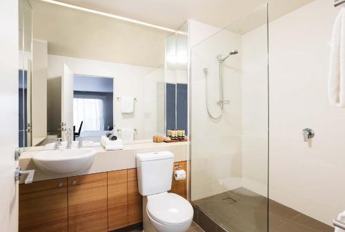 a bathroom with a toilet and a sink and a shower at The Old Woolstore Apartment Hotel in Hobart