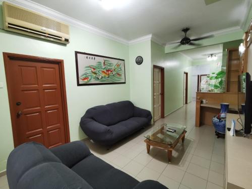 a living room with a blue couch and a coffee table at DIY Palm Court 3BR Apartment, 7 Guests in Kuantan
