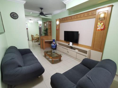a living room with two blue couches and a flat screen tv at DIY Palm Court 3BR Apartment, 7 Guests in Kuantan