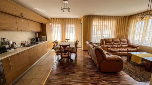 a kitchen and living room with a table and a couch at Villa Orpheus in Chepelare