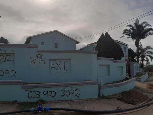 a white house with graffiti on the side of it at LINGE'S LODGE EXTENSION in Lusikisiki