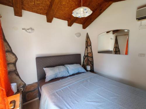 a bedroom with a bed in a room with a ceiling at Rustic house with private Pool in Šišan