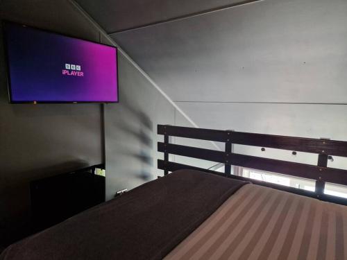 a bedroom with a bed and a tv on the wall at Sea Breeze in Brighton Marina with Free Parking in Brighton & Hove