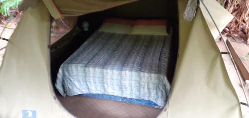 a small bedroom with a bed in a tent at Hazyview Adventure Backpackers in Hazyview