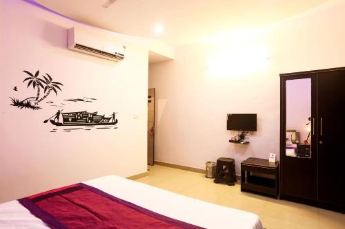a bedroom with a bed and a palm tree stencil on the wall at OYO Hotel Plaza Inn in Bhopal
