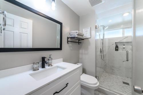 a white bathroom with a sink and a shower at Disneyland Dream Villa 5 BR 3 BA Arcade Games in Anaheim