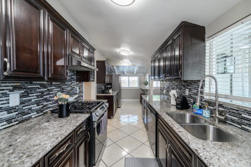 a kitchen with wooden cabinets and a sink at Disneyland Dream Villa 5 Bedroom 3 Bath Theater Games Pool Table in Anaheim