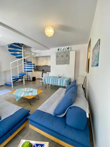 a living room with a blue couch and a table at Cozy blue in Ialyssos