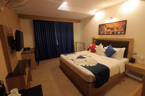 a hotel room with a bed and a television at MJ Avyanna Resort & Convention Centre, Bengaluru in Bengaluru