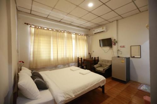 バンコクにあるOYO 75440 Nara Hostelのベッドと椅子付きの小さな部屋です。