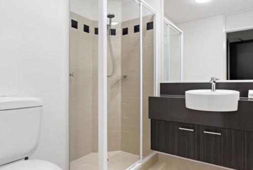 a bathroom with a shower and a sink and a toilet at 109 Simply Devine Hay St 2x2apt Poolgym in Perth