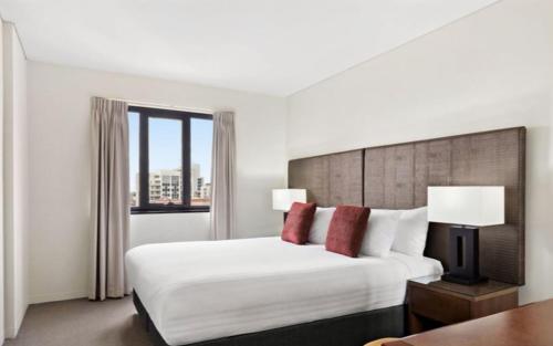 a hotel room with a bed and a window at 109 Simply Devine Hay St 2x2apt Poolgym in Perth