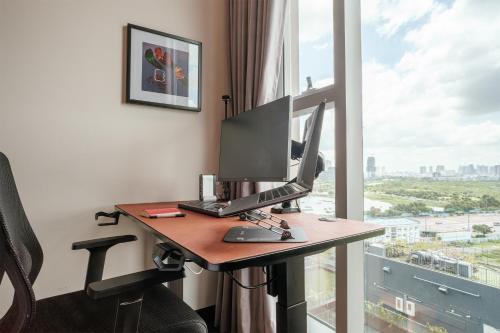 - un ordinateur sur un bureau dans une chambre avec fenêtre dans l'établissement Lux Executive Residence @ Empire City by CIRCADIAN, à Hô-Chi-Minh-Ville