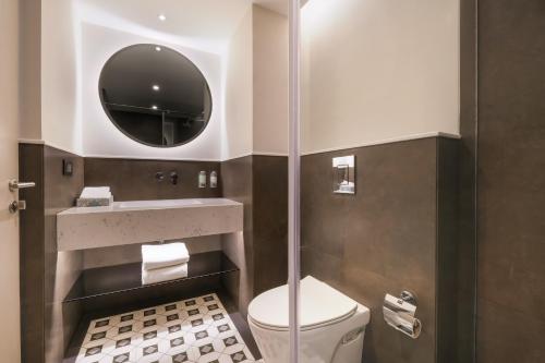 a bathroom with a toilet and a mirror at 7 Apple Hotel Jal Mahal, Jaipur in Jaipur