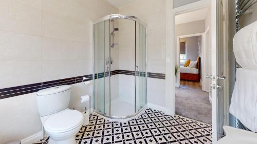 a bathroom with a toilet and a shower at Stunning 5 Bed Detached Home Nottingham in Nottingham