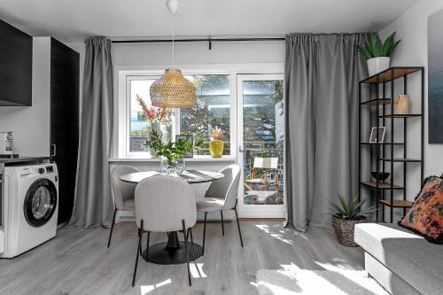 een woonkamer met een tafel en een raam bij Venture Vacation - Cozy and Central Apartment in Reykjavík