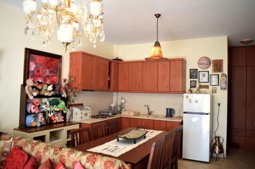 uma cozinha com uma mesa e um frigorífico branco em Helen's Cozy Apartment em Litochoro
