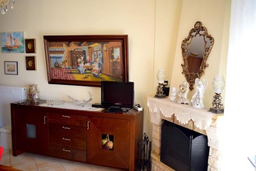 a living room with a fireplace and a mirror at Helen's Cozy Apartment in Litochoro
