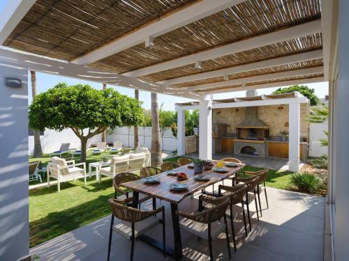 a patio with a table and chairs and a fireplace at Sea La Vie in Adelianos Kampos