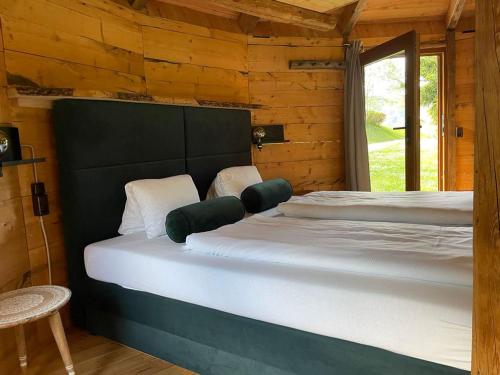 1 dormitorio con 2 camas en una cabaña de madera en EuroParcs Wörthersee, en Schiefling am See