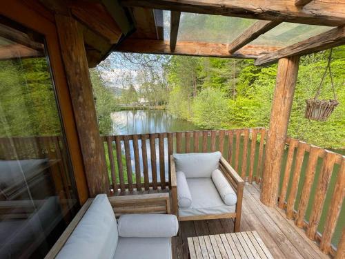 a screened in porch with a couch and a chair at EuroParcs Wörthersee in Schiefling am See