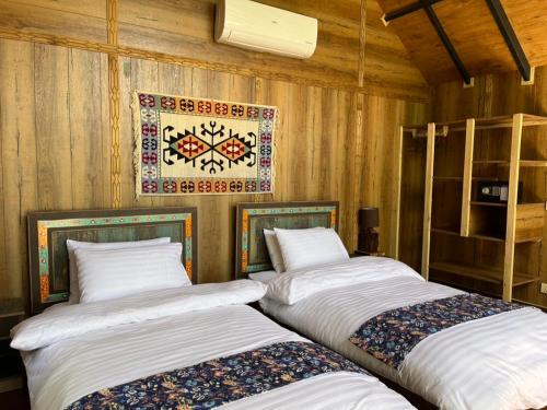 two beds sitting next to each other in a room at The 2 Magpies, Hunza in Alīābād