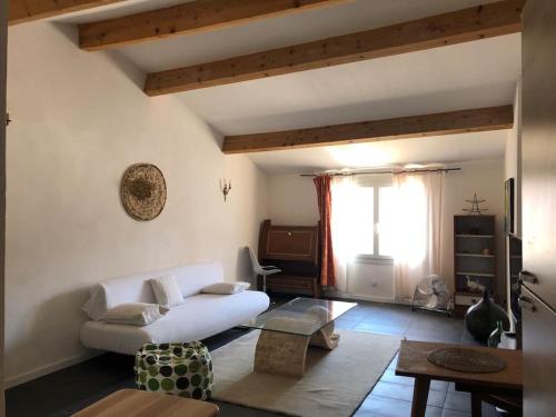 un salon avec un canapé blanc et une table dans l'établissement Appartement avec terrasse., à Apt