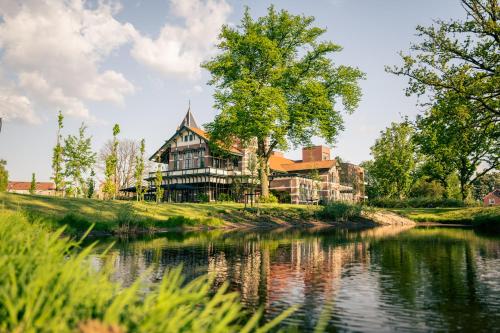 a large house on the side of a river at Wapen van Hengelo Residence Suites - digital key by SMS and email in Hengelo