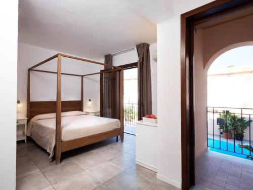 a bedroom with a canopy bed and a balcony at Moresco Resort in Lampedusa