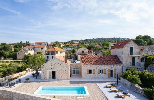einen Luftblick auf eine Villa mit einem Pool in der Unterkunft NEW! Stone Villa Olim Civitas with 3 bedrooms, private pool, and sea views in Škrip