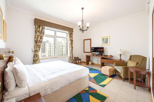 Habitación de hotel con cama y sala de estar. en Royal Club By RVHR, Palm Jumeirah, en Dubái