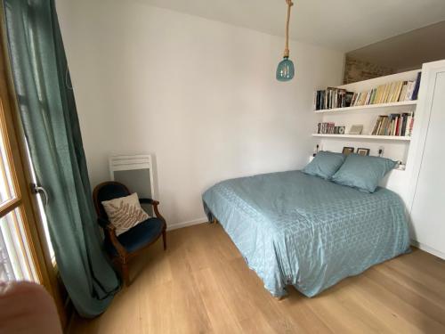1 dormitorio con cama, silla y estante para libros en Enormous charm T2 historic center laundry Fiber, en Perpiñán