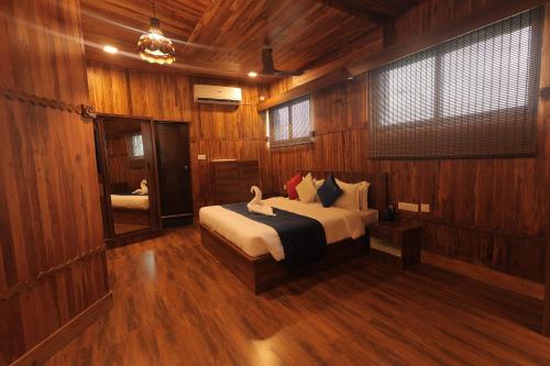 a bedroom with a bed in a wood paneled room at MJ Avyanna Resort & Convention Centre, Bengaluru in Bengaluru