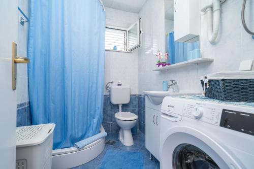 a bathroom with a washer and a washing machine at Villa Planika in Slano