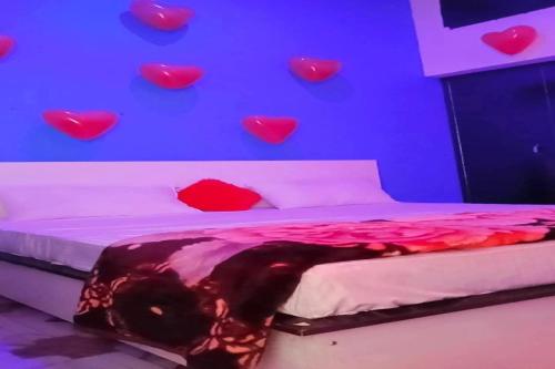 a bedroom with hearts on the wall and a bed at OYO Hotel Rosewood in Palwal
