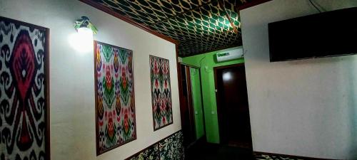 a hallway with a green door and a flat screen tv at B&B, Khiva ,, Abdullah " in ichan Kala in Khiva