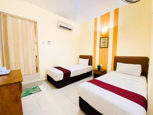 a hotel room with two beds and a desk at Sun Inns Hotel Equine, Seri Kembangan in Seri Kembangan